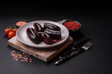 Lezzetli siyah kan sosisi veya siyah beton arka planda ızgara baharat ve otlu kara puding.