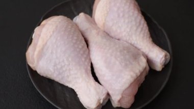 Çiğ tavuk budu, tuzlu, baharatlı ve ızgara için hazırlanmış otlar.