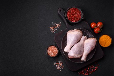 Çiğ tavuk budu, tuzlu, baharatlı ve ızgara için hazırlanmış otlar.