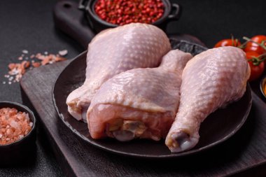 Çiğ tavuk budu, tuzlu, baharatlı ve ızgara için hazırlanmış otlar.