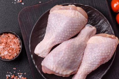 Çiğ tavuk budu, tuzlu, baharatlı ve ızgara için hazırlanmış otlar.