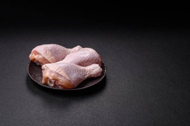 Çiğ tavuk budu, tuzlu, baharatlı ve ızgara için hazırlanmış otlar.