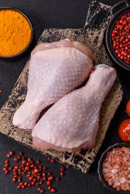 Çiğ tavuk budu, tuzlu, baharatlı ve ızgara için hazırlanmış otlar.