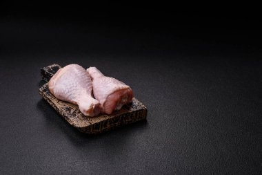 Çiğ tavuk budu, tuzlu, baharatlı ve ızgara için hazırlanmış otlar.