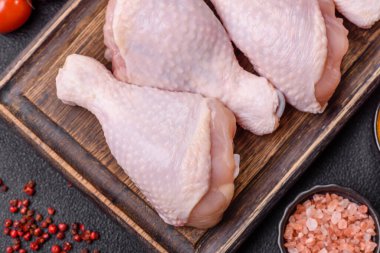 Çiğ tavuk budu, tuzlu, baharatlı ve ızgara için hazırlanmış otlar.