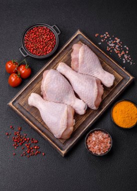 Çiğ tavuk budu, tuzlu, baharatlı ve ızgara için hazırlanmış otlar.