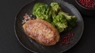 Lezzetli taze brokoli, dokulu beton arka planda seramik bir tabakta buğulanmış.