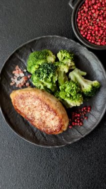 Lezzetli taze brokoli, dokulu beton arka planda seramik bir tabakta buğulanmış.