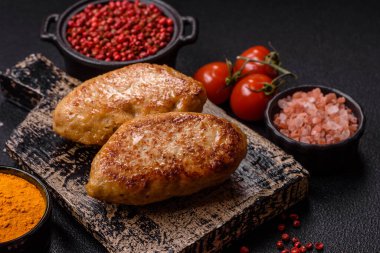 Lezzetli taze kıymalı balık pirzolası. Esmer arka planda baharatlar ve otlarla birlikte.