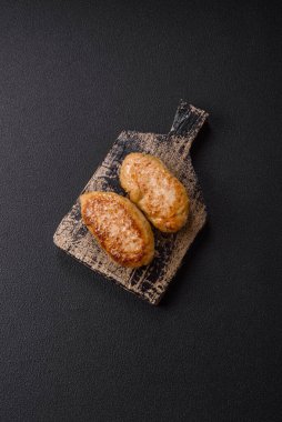 Lezzetli taze kıymalı balık pirzolası. Esmer arka planda baharatlar ve otlarla birlikte.