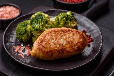 Lezzetli taze brokoli, dokulu beton arka planda seramik bir tabakta buğulanmış.