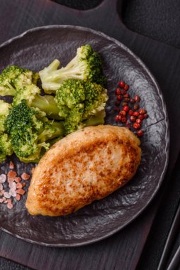 Lezzetli taze brokoli, dokulu beton arka planda seramik bir tabakta buğulanmış.