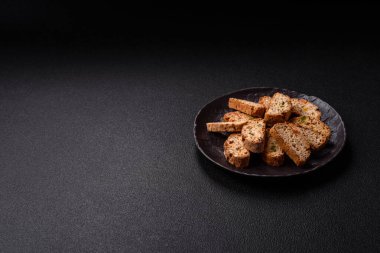 Taze pişmiş İtalyan cantuccini kurabiyeleri fındıklı ve şekerli meyveler koyu beton arka planda