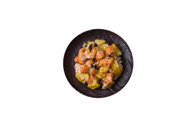 Fırında somon parçaları, patates, peynir ve tuzlu zeytinli, baharatlı ve otlu beyaz arka planda.