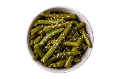 Zeytin yağı, susam tohumu, tuz ve baharatlı bir tabakta haşlanmış yeşil fasulye.