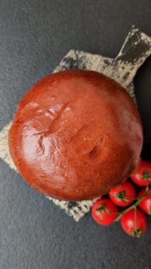 Köfteli lezzetli burger, kızarmış yumurta, pastırma, otlar, sos, tuz ve baharatlar koyu beton arka planda.