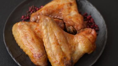 Koyu beton arka planda tuzlu ve baharatlı ızgara tavuk kanadı.