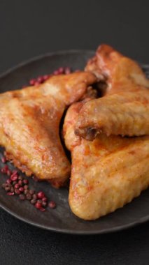 Koyu beton arka planda tuzlu ve baharatlı ızgara tavuk kanadı.