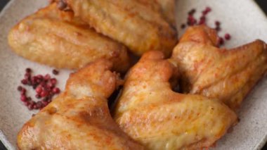 Koyu beton arka planda tuzlu ve baharatlı ızgara tavuk kanadı.