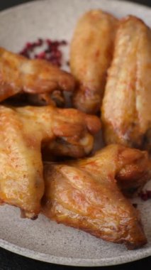 Koyu beton arka planda tuzlu ve baharatlı ızgara tavuk kanadı.