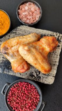 Koyu beton arka planda tuzlu ve baharatlı ızgara tavuk kanadı.