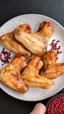 Koyu beton arka planda tuzlu ve baharatlı ızgara tavuk kanadı.