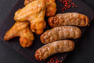 Koyu beton arka planda tuzlu ve baharatlı ızgara tavuk kanadı.