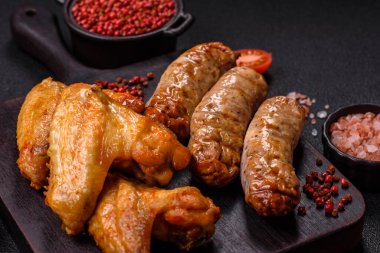 Koyu beton arka planda tuzlu ve baharatlı ızgara tavuk kanadı.