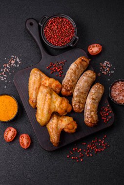 Koyu beton arka planda tuzlu ve baharatlı ızgara tavuk kanadı.