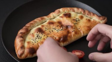 Cheburek etli börek ve şifalı otlar. Siyah beton arka plan. Üst görünüm
