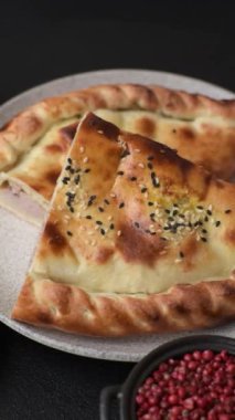 Cheburek meat pastry pie with herbs. Black concrete background. Top view