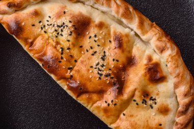Cheburek etli börek ve şifalı otlar. Siyah beton arka plan. Üst görünüm