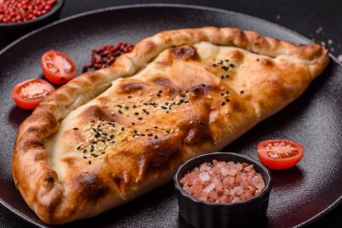 Cheburek etli börek ve şifalı otlar. Siyah beton arka plan. Üst görünüm