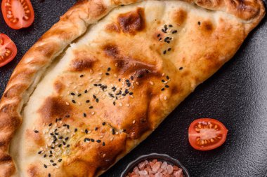 Cheburek etli börek ve şifalı otlar. Siyah beton arka plan. Üst görünüm