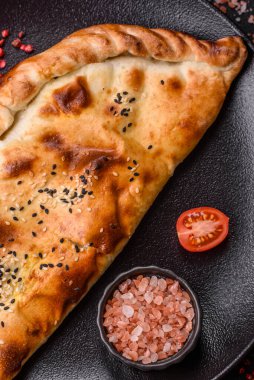 Cheburek etli börek ve şifalı otlar. Siyah beton arka plan. Üst görünüm