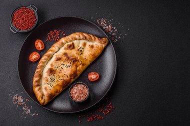 Cheburek etli börek ve şifalı otlar. Siyah beton arka plan. Üst görünüm