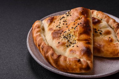 Cheburek etli börek ve şifalı otlar. Siyah beton arka plan. Üst görünüm