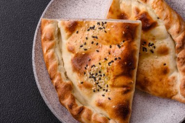 Cheburek etli börek ve şifalı otlar. Siyah beton arka plan. Üst görünüm