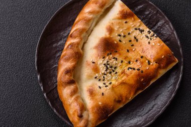 Cheburek etli börek ve şifalı otlar. Siyah beton arka plan. Üst görünüm