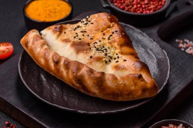 Cheburek etli börek ve şifalı otlar. Siyah beton arka plan. Üst görünüm