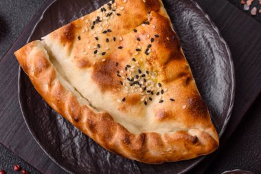 Cheburek etli börek ve şifalı otlar. Siyah beton arka plan. Üst görünüm