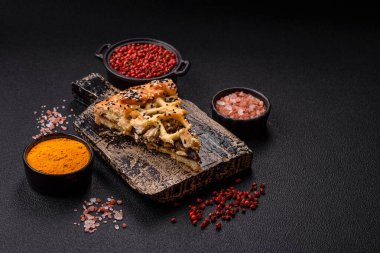 Fransız kiş, tavuk ya da somon, peynir, tuz, baharat ve koyu beton arka planda bitkiler.