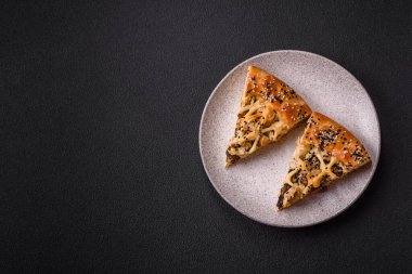 Fransız kiş, tavuk ya da somon, peynir, tuz, baharat ve koyu beton arka planda bitkiler.