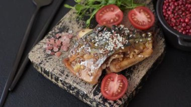 Izgara uskumru fileto, sebzeli, tuzlu ve baharatlı, koyu beton arka planda.