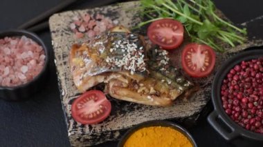 Izgara uskumru fileto, sebzeli, tuzlu ve baharatlı, koyu beton arka planda.