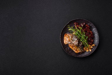 Izgara uskumru fileto, sebzeli, tuzlu ve baharatlı, koyu beton arka planda.