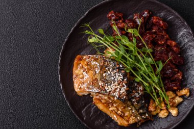 Izgara uskumru fileto, sebzeli, tuzlu ve baharatlı, koyu beton arka planda.