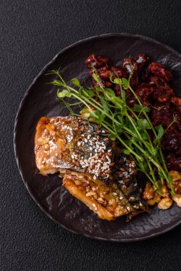 Izgara uskumru fileto, sebzeli, tuzlu ve baharatlı, koyu beton arka planda.