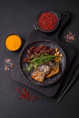 Izgara uskumru fileto, sebzeli, tuzlu ve baharatlı, koyu beton arka planda.