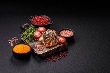 Izgara uskumru fileto, sebzeli, tuzlu ve baharatlı, koyu beton arka planda.